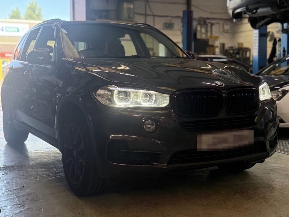 A black BMW X5 parked inside the T&K Performance workshop